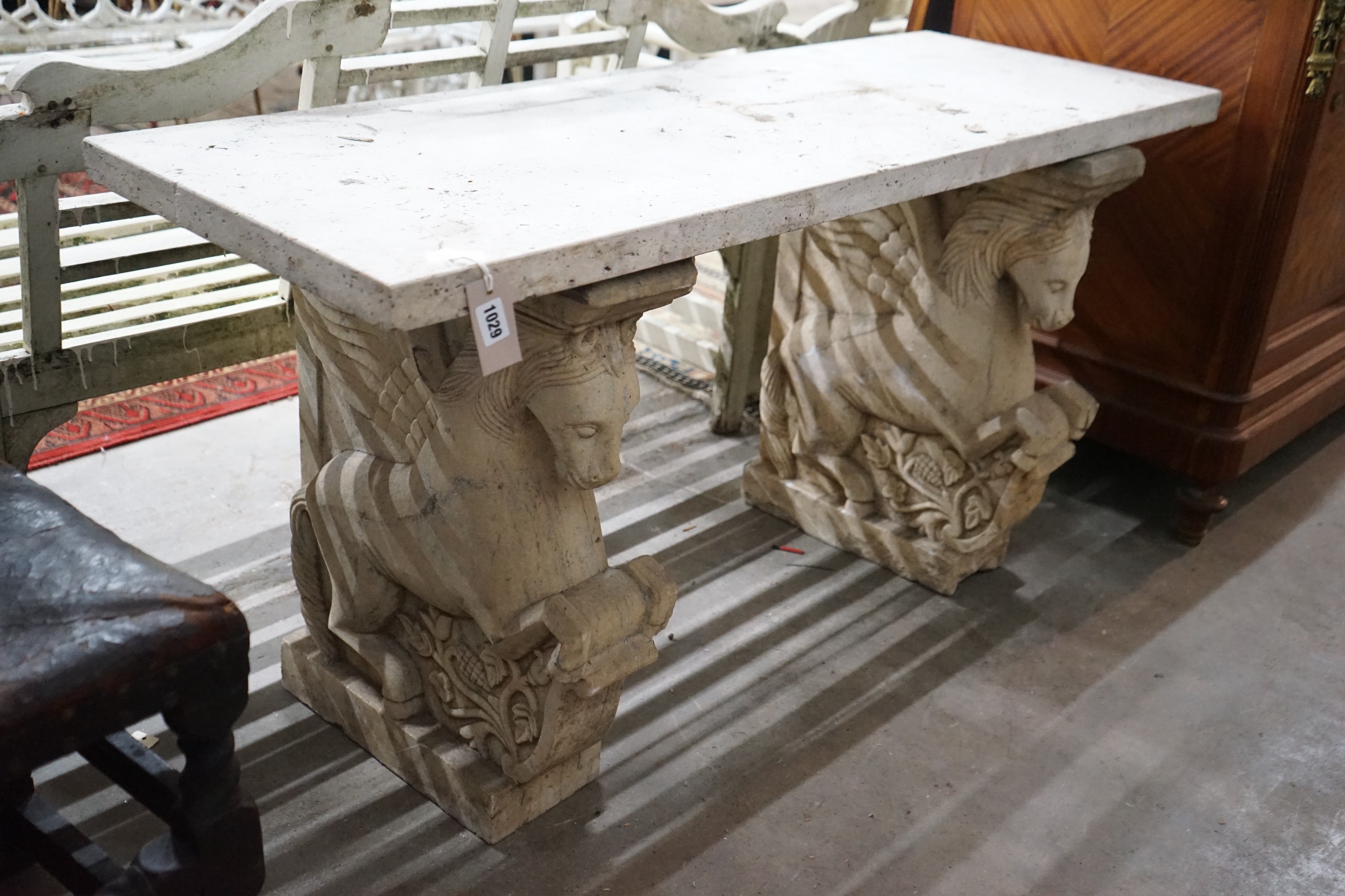 A carved stone Pegasus console table, width 127cm, depth 46cm, height 66cm